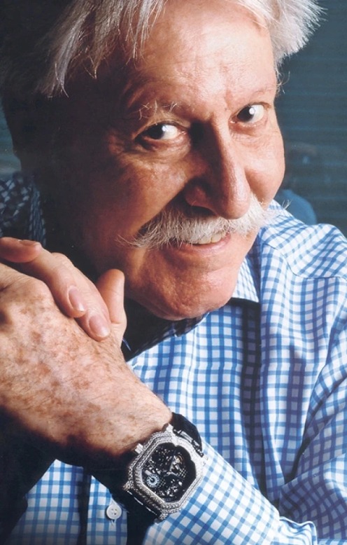 Gérald Genta souriant au poignet une montre octogonale squelettée sertie de diamants